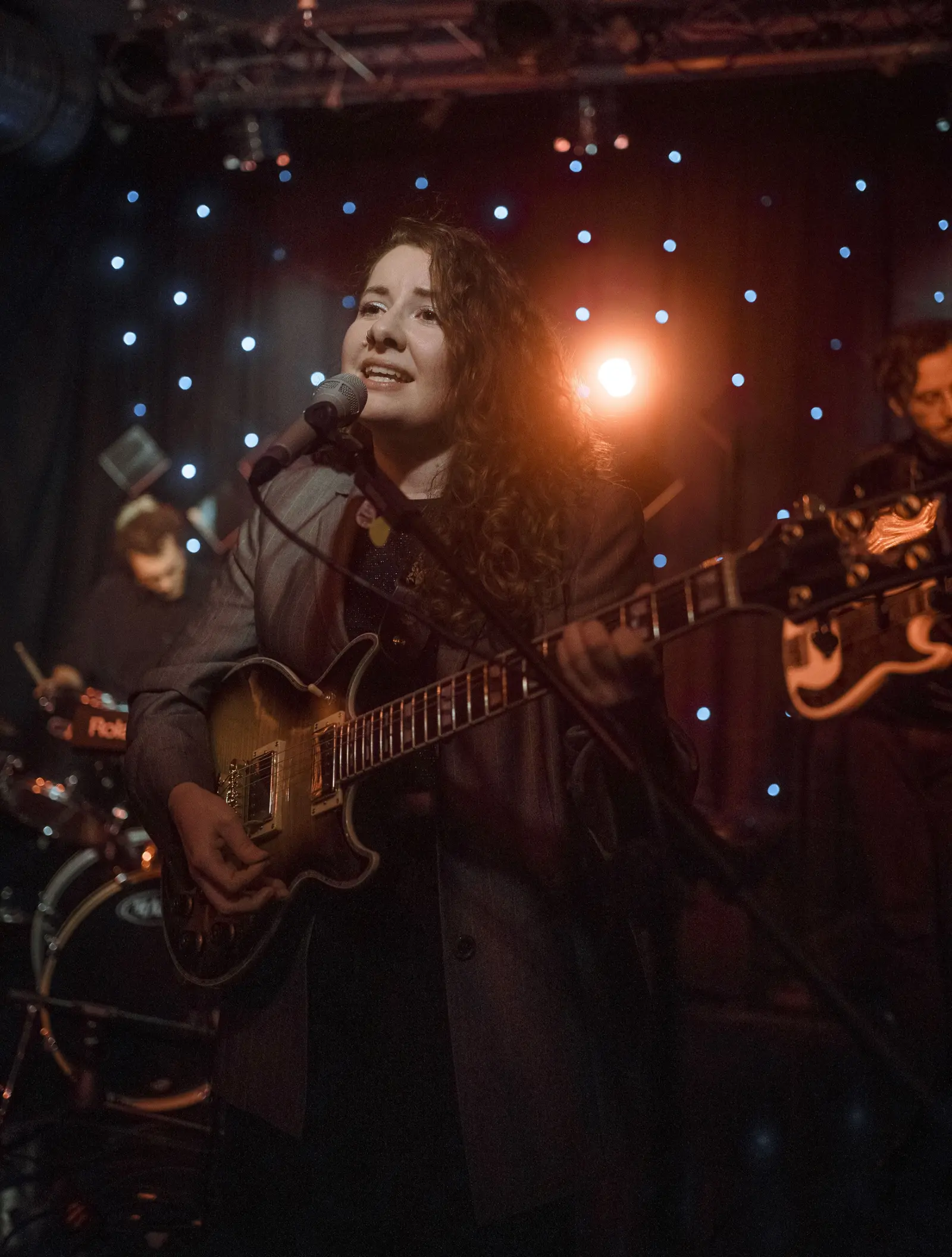 Corinna Böhm singt und spielt E-Gitarre auf einer Bühne